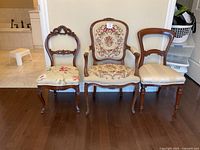 All three chairs side by side against wall on wood floor