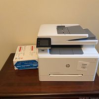 Printer front and left side with touchscreen and ream of paper beside it