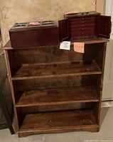 Photo showing the wooden three-shelf unit with a keepsake box and a wooden games/storage box placed on top.