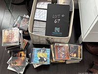 Photo showing a mix of CDs stacked and in a basket featuring various genres and artists