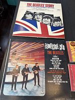 Top view of The Beatles' Story and Something New vinyl album covers showing artwork and part of the covers' details.