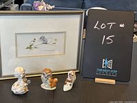 Photo showing three Beatrix Potter figurines and the framed print of Strawberry Mouse by Valerie Pfeiffer, along with lot sign.