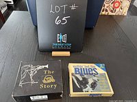 Photo showing both CD compilation sets The Verve Story Jazz box and Nuthin' But The Blues 2-CD set on a table with background signage.