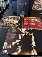 Three vinyl albums displayed with case labeled Lot #54, showing front covers of each album