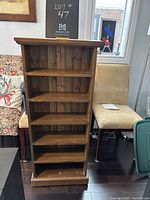 Front view of the wooden shelf showing all six shelves and adjustable feet at the base.