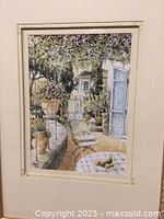 Close-up of the print showing the garden scene with chairs, plants, and blue door.