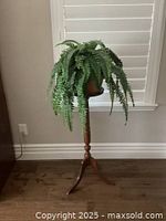 Front view of the solid wood plant stand with artificial fern, showing height and design