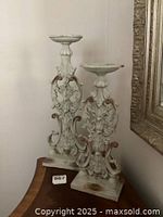 Two wood shabby chic candle stands displayed on a dark wood curved surface, seen front and side.