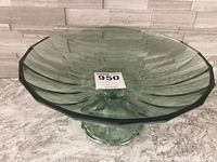 Top view of deep green glass footed bowl showing swirled pattern and wide fluted rim