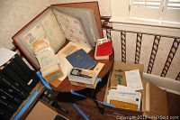 Overview of lot with various stamp albums, loose envelopes, a blue book, and magnifier
