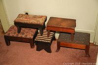 Five vintage step stools grouped together showing varied upholstery and one plain wood stool.