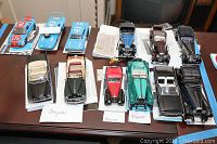 Overview of six Franklin Mint die cast model cars on table