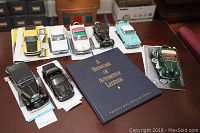 All eight die cast cars displayed on a table along with the Franklin Mint catalog book, showing the size, variety, and condition of models.
