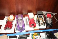 Five Franklin Mint model cars displayed side-by-side on a tabletop