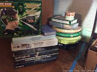 Green Hulk walkie talkie with night vision and stack of various vintage jigsaw puzzle boxes including Chesapeake Bay navigation chart and Springbok brand puzzles.