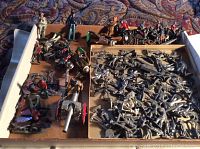 Wide view of painted and unpainted figures arranged in tray and box