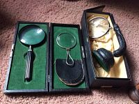All three vintage magnifying glasses shown open in their respective cases or standing, highlighting the variety of handle styles and sizes with felt and satinlined boxes