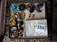 Tray with all nine brooches and three necklaces laid out