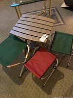 Top view showing three fabric stools (two green, one red) and beige slatted foldable table.
