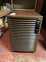 Front view of Kenmore 38 dehumidifier showing brown plastic horizontal slats and control panel on top right side.