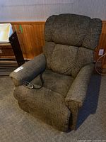 Full frontal view of the La-Z-Boy recliner showing the armrests, cushioned seat, and remote resting on chair seat.
