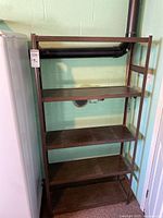 Full view of the metal shelf unit with four wooden shelves, showing the overall structure and condition.