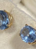 Front-closeup of one oval synthetic blue spinel gemstone showing faceted cut and color