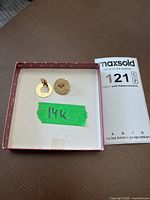 Pair of earrings in box with green tape marked ‘14K’ and MaxSold tag