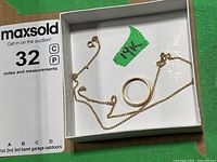 Ring and chain displayed in auction box with 14K marking