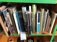 Books on history, art, and Kingston arranged on a wooden shelf with varied covers and sizes, including titles such as 'The Incredible Canadian' and 'The Fate of a Nation'.
