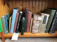 Shelf of assorted older books showing titles such as 'Einstein and Religion' and 'Petit Larousse.' Various book sizes and conditions visible.