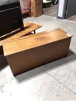 Full view of wood chest showing rectangular shape and veneer surface.