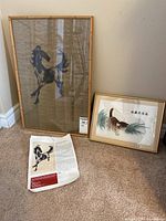 View of the two framed art pieces: a vertical horse print with bamboo frame and a smaller framed kitten embroidery.