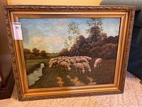 Overall view of framed painting leaning against furniture on floor