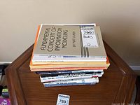 Stack of 10 non-fiction books on a wooden surface, titles visible include Information Modeling, Microsoft Visio User Guide, Enterprise Architecture, Strategic Benchmarking.