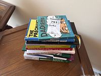 Stack of eight non-fiction books including titles on DADisms, The Pregnant Male, Living the Good Life, Change Your Brain Change Your Body, Mastering the Winds of Change, The Wealthy Barber Returns, and Men's Health and Diet.
