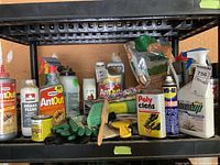 Full view of shelf holding various chemical products including AntOut, WD-40, RoundUp, Poly Clens, gloves, brushes. Packaging looks opened and partially used.