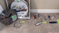Overview of two wall clocks and multiple keychains laid on carpet