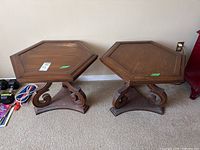 Pair of matching hexagonal wooden end tables with decorative raised edges and carved legs seen from above and side angles.