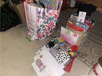 Large floral reusable shopping bag and additional gift bags with assorted gift wraps and tissue paper inside.