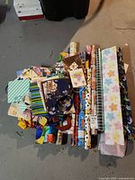 Overview of assorted gift wrap rolls and gift bags stacked together showing different patterns and sizes.