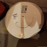 Top-down view of the round white grilling machine with control dial and labeling visible