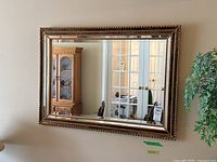Front view of the rectangular mirror showing the detailed ornate carved frame with leaf/rope motifs and reflective surface.