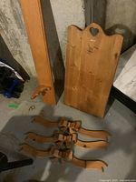 Photo showing the oak plate rail standing upright, wooden calendar holder with heart cutout on top, and three wooden decorative bows laid flat in front.