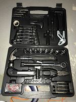Black molded plastic case tool set with hammer, ratchet wrench, sockets, pliers, hex keys, screwdriver bits and other tools