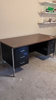 Front and side view of vintage office desk showing wood laminate top, black metal drawer units, and chrome legs.