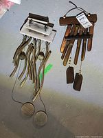 Photo showing two wind chimes, one with metal tubes and white wooden top, the other with wooden tubes and dark wooden top.