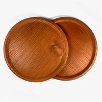 Top view of two overlapping circular bentwood plates highlighting the warm wood tone and grain.
