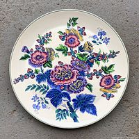 Full top view of the round platter showing the floral Hollyhock pattern in multiple colors on light background.