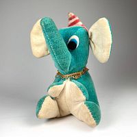 Front view of the vintage blue elephant elf plush toy doll, showing details of hat, eyes, and gold tinsel collar.